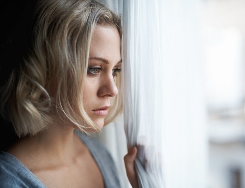 depressed-woman-looking-out-window-500
